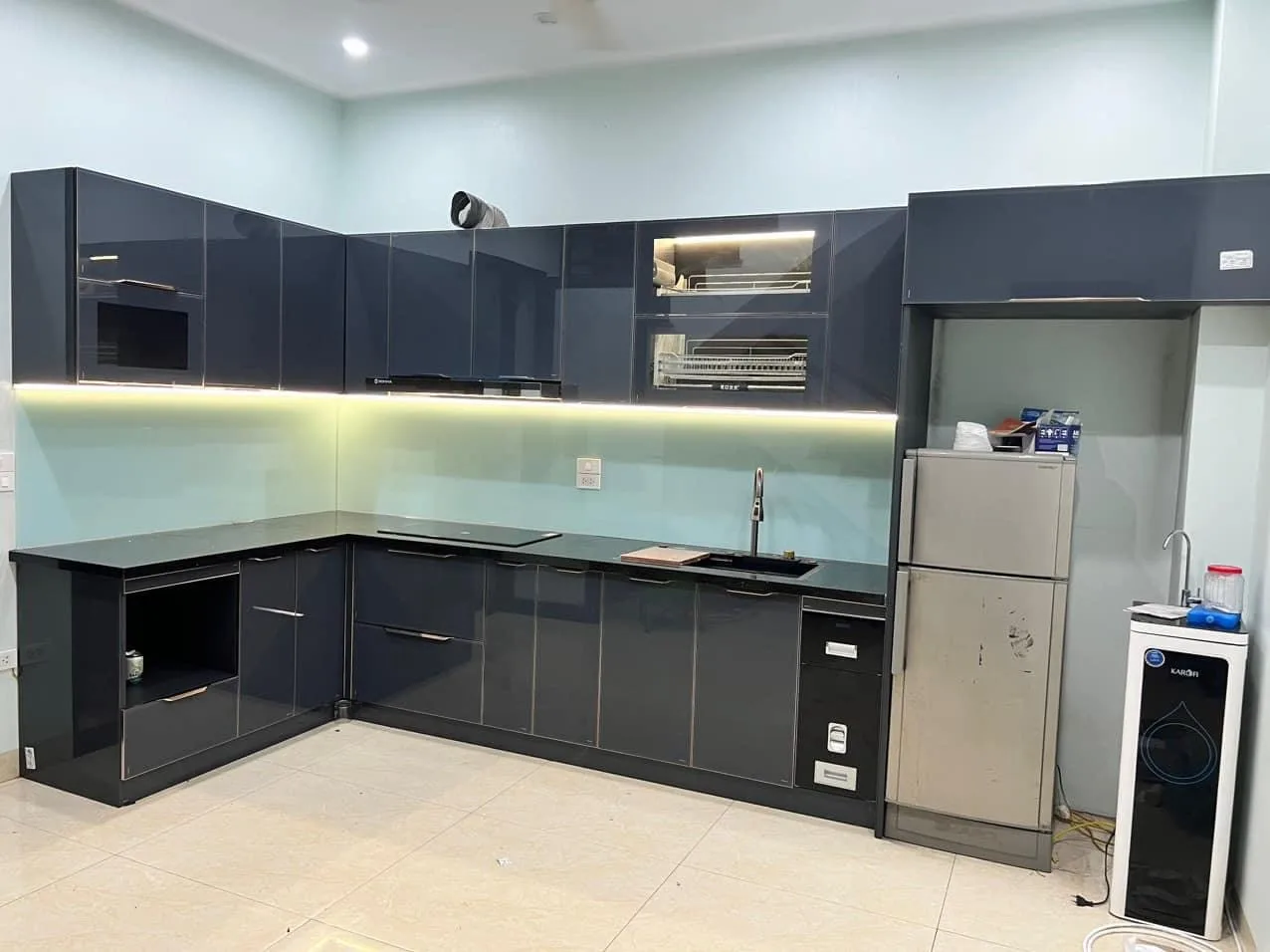 Mẫu tủ bếp cánh kính màu xanh than phối kính ốp tường ngọc bích cho gia chủ mệnh Thủy