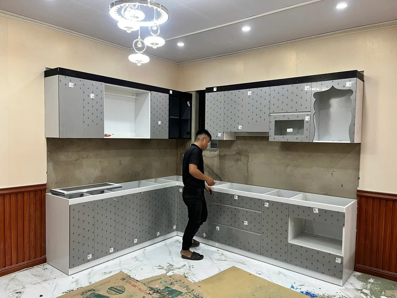 Người thợ đang lắp đặt hệ tủ bếp tại công trình trong tư liệu EA