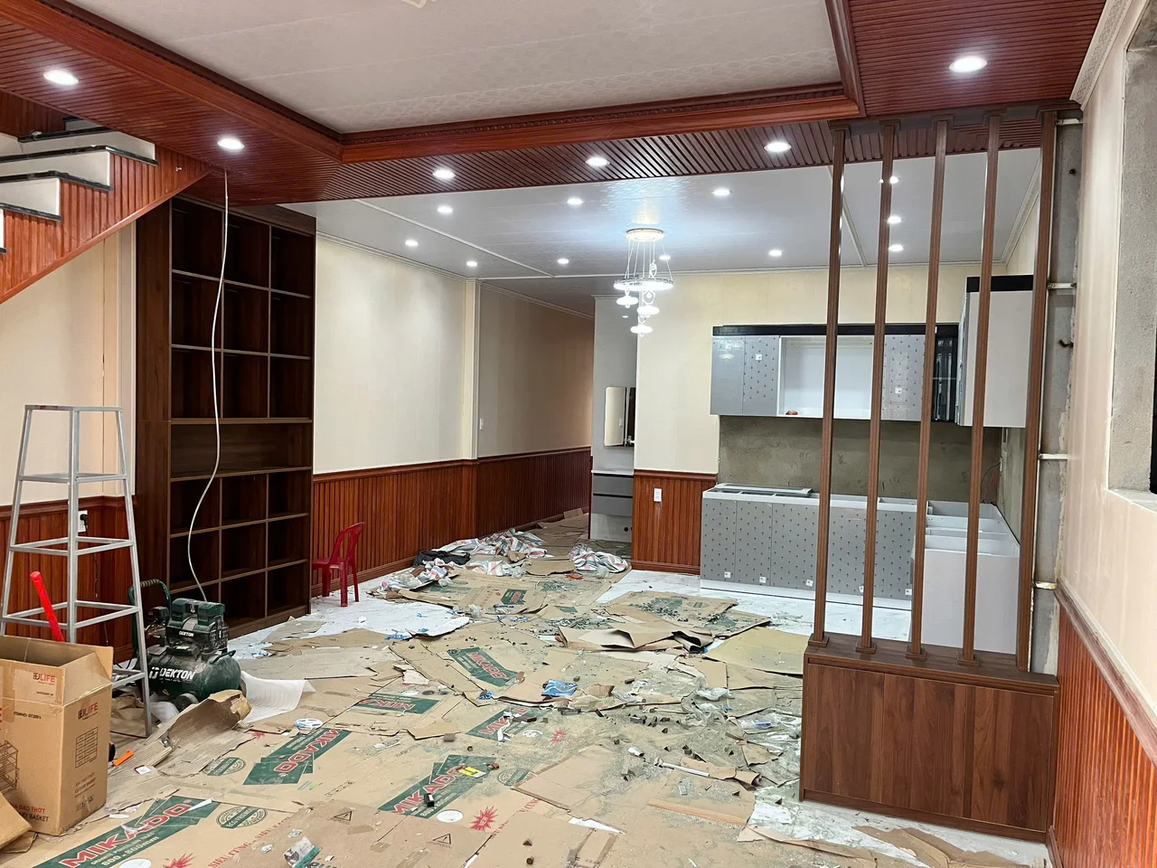 Vách nan và hệ kệ mở tông gỗ trong giai đoạn lắp đặt phòng khách