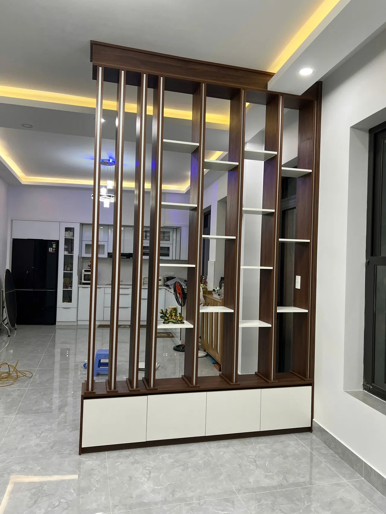 Vách lam gỗ ngăn phòng khách màu vân gỗ tự nhiên ấm cúng kết hợp ánh sáng dịu mắt
