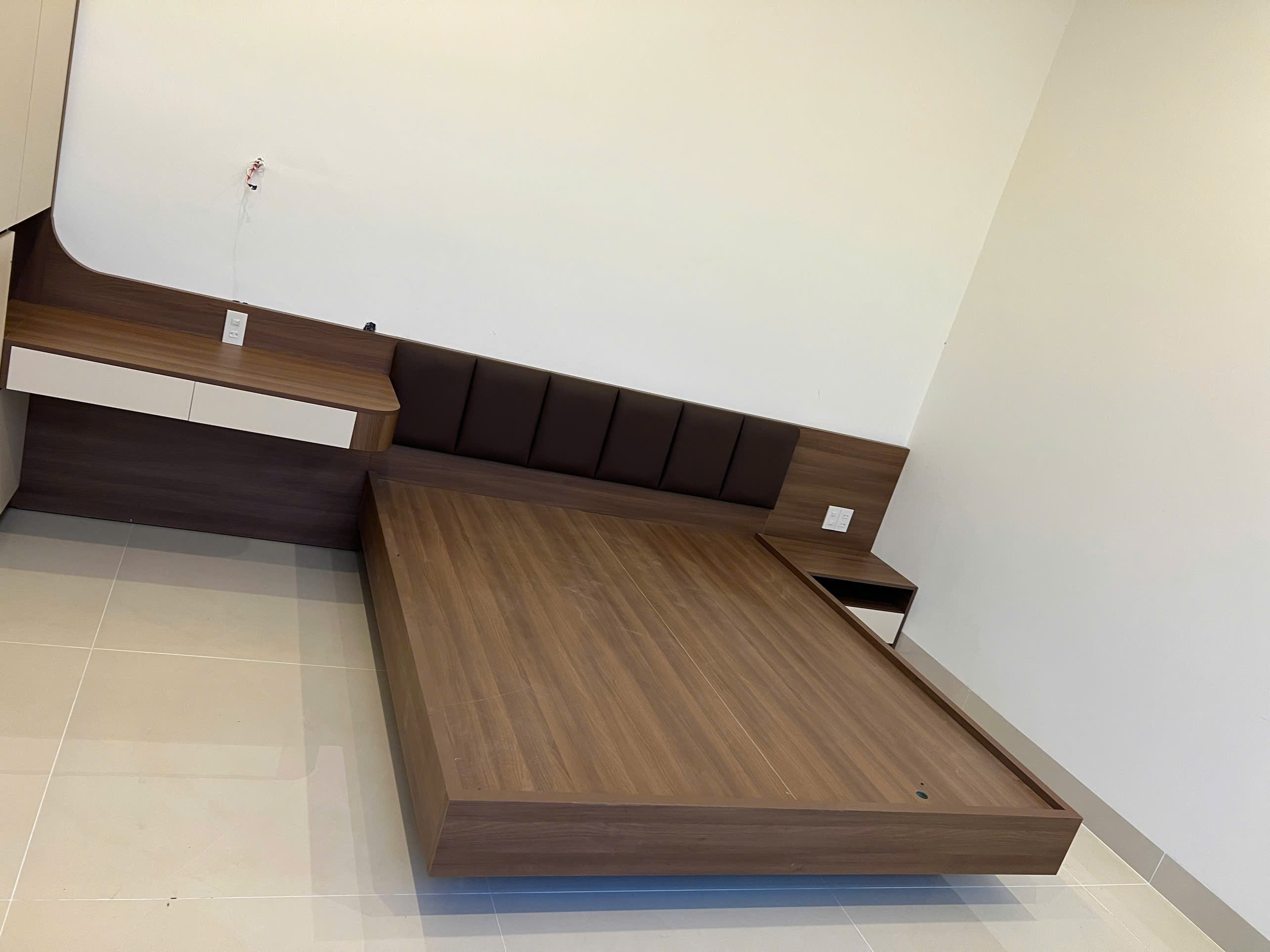 Phòng ngủ master gỗ MDF màu nâu đậm với vách ốp đầu giường và tủ áo cánh mở, góc nhìn 3