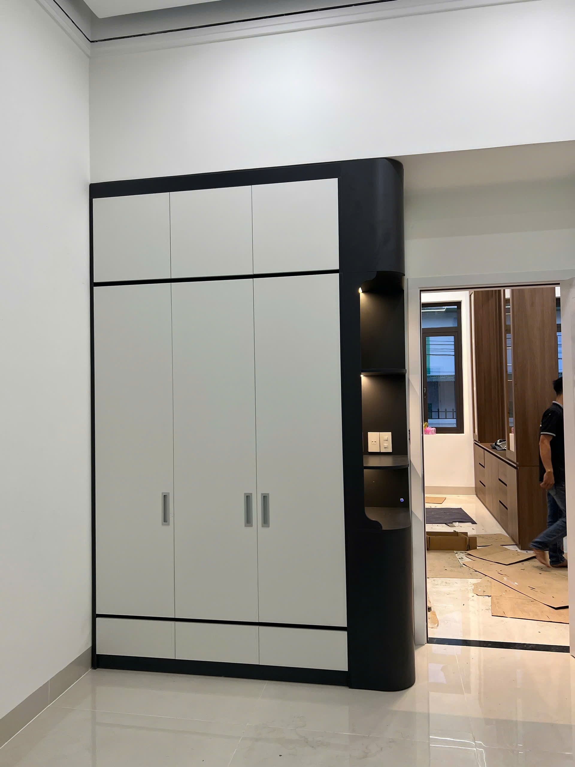 Phòng ngủ master gỗ MDF màu nâu đậm với vách ốp đầu giường và tủ áo cánh mở, góc nhìn 11
